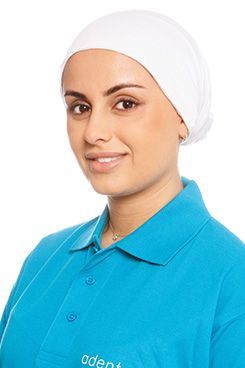 Eine Frau in einem blauen Hemd lächelt in die Kamera.