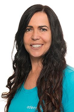 Technische Sterilisationsassistentin Ellen Eine Frau mit langen Haaren trägt ein blaues Hemd und lächelt.