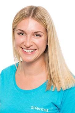 Zahnmedizinische Prophylaxeassistentin Julia Eine Frau in einem blauen Hemd lächelt in die Kamera.