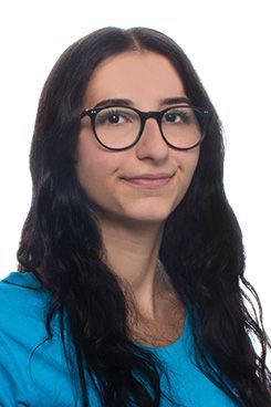 Fachangestellte Sophia Eine Frau mit Brille und blauem Hemd lächelt in die Kamera.