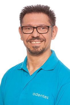 Zahnmedizinische Fachangestellte Eine Frau in einem blauen Hemd lächelt in die Kamera.