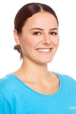 Physiotherapeutin Clara Eine Frau in einem blauen Hemd lächelt in die Kamera.