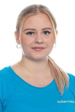 Zahnmedizinische Fachangestellte Tatjana Die Frau trägt ein blaues Hemd und eine Halskette.