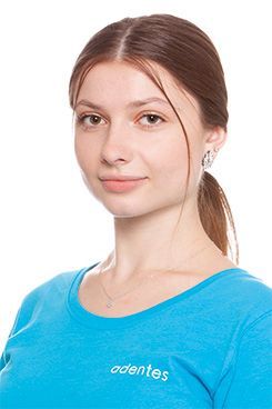 Eine Frau trägt ein blaues Hemd und lächelt in die Kamera.