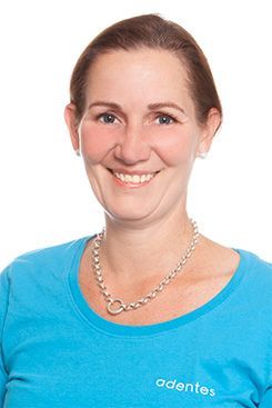 Technische Sterilisationsassistentin Ellen Eine Frau mit langen Haaren trägt ein blaues Hemd und lächelt.