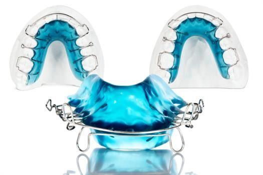 Zahnspange Ein blauer Zahnhalter liegt auf einer weißen Oberfläche.