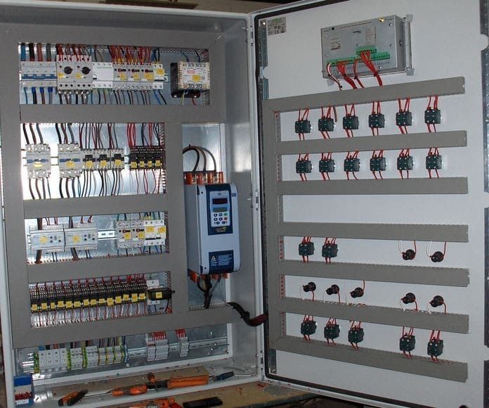Panel de control con componentes eléctricos y cableado dentro de una carcasa metálica.