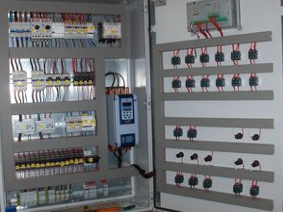 Panel de control eléctrico con cables, interruptores y variador de frecuencia.