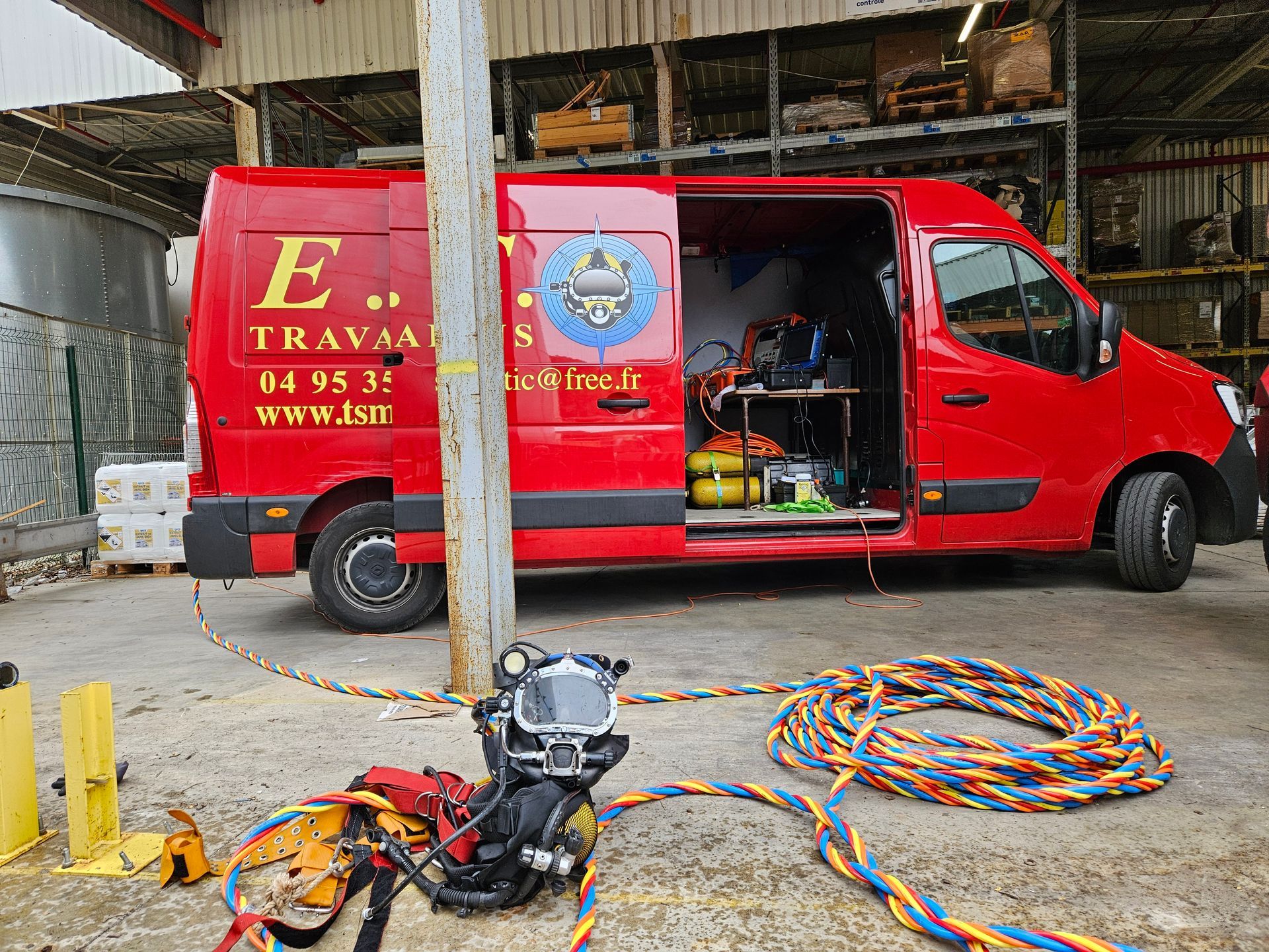 Fourgonnette rouge avec porte latérale ouverte et équipement de plongée