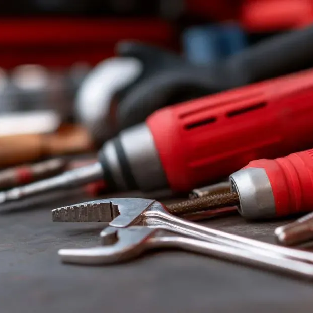 Trabajador de control de plagas con traje protector rociando el piso de una cocina, con insectos marrones cerca.
