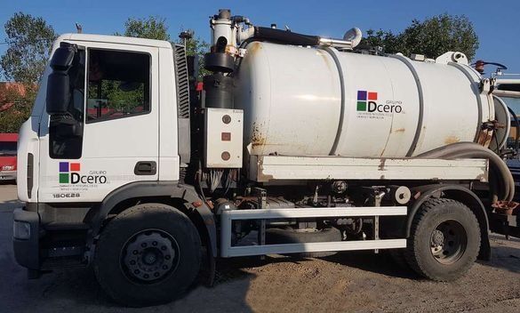 Un camión de vacío blanco está estacionado en un estacionamiento.