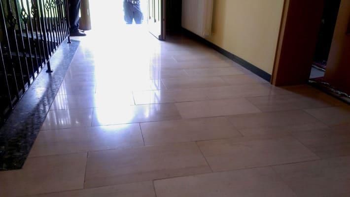 Ein Flur mit Fliesenboden und einer Treppe im Hintergrund