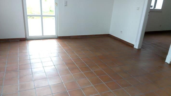 Ein leerer Raum mit gefliestem Boden und weißen Wänden