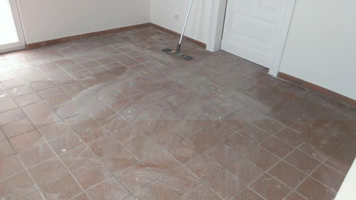 In einem Zimmer steht ein Wischmopp auf dem gefliesten Boden.