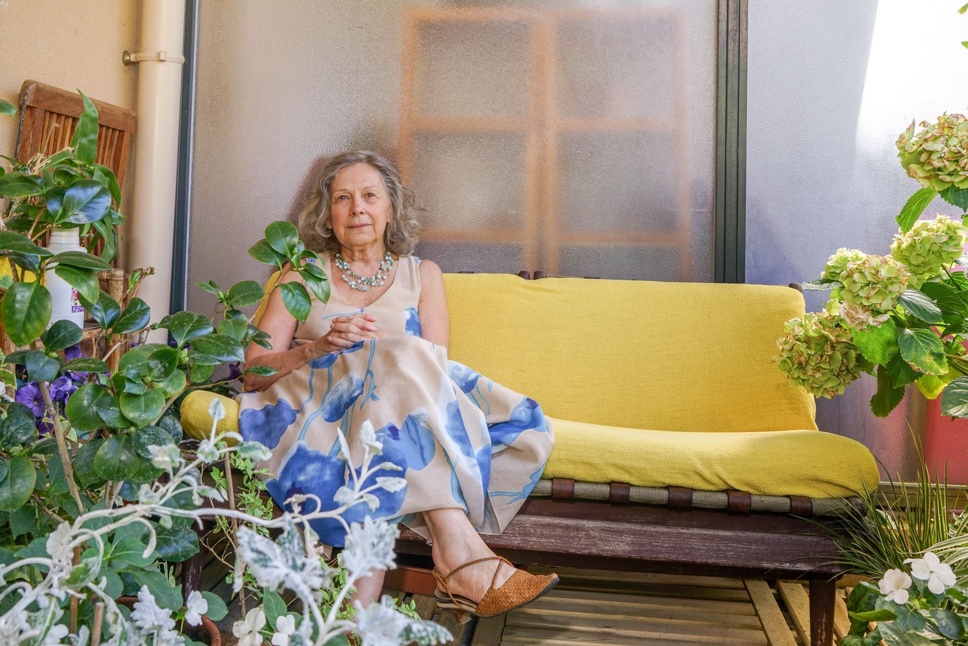 Psychologue Anne-Marie Tchakrian assise sur un canapé jaune.