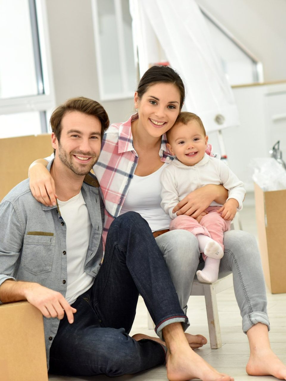 Deux parents et leur jeune garçon sont assis dans une pièce lumineuse.