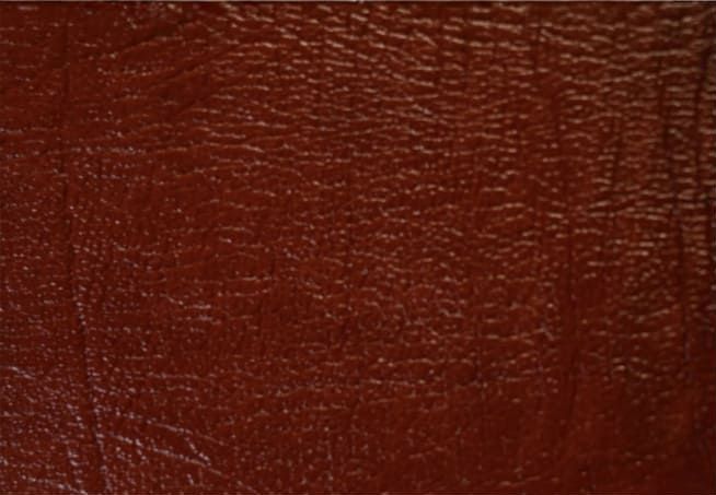 Primer plano de una superficie de cuero texturizado de color rojo oscuro.