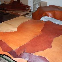 Una pila de cuero marrón reposa encima de una mesa.