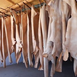 Un montón de piezas de cuero cuelgan de un estante.