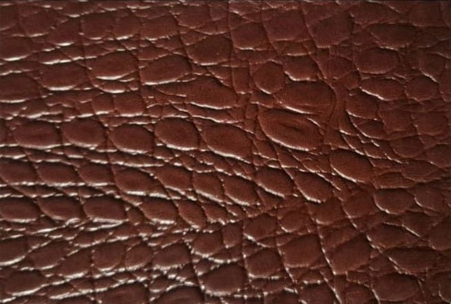 Primer plano de la textura del cuero marrón con vetas y pliegues visibles.
