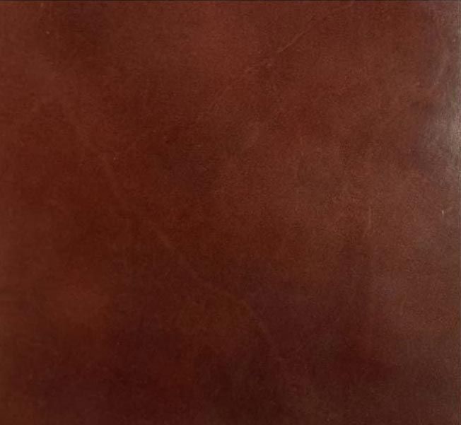 Primer plano de una superficie texturizada de color marrón rojizo con sutiles sombras.