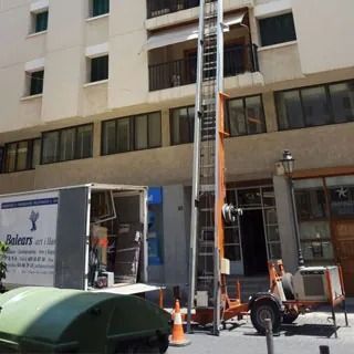 Un camión de Balears está estacionado frente a un edificio.