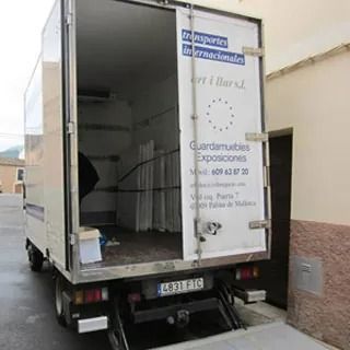 Una camioneta blanca con la puerta abierta y un cartel en la parte trasera que dice 