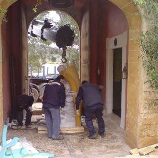 Un grupo de hombres está trabajando en un objeto grande en un edificio.