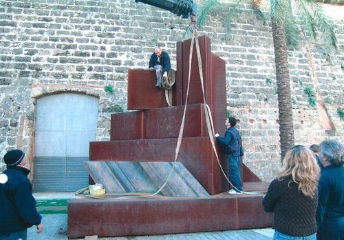 Un grupo de personas está de pie alrededor de una gran escultura.