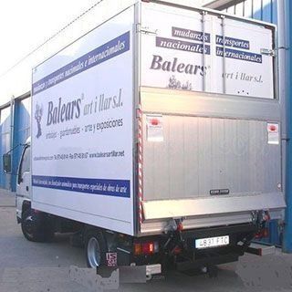 Un camión blanco de Balears está estacionado frente a un edificio.