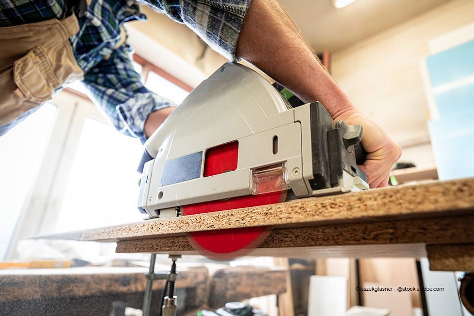 Arbeiter schleift Holz