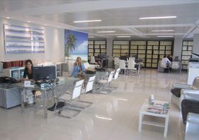 Un grupo de personas están sentadas en escritorios en una oficina.