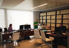 Un grupo de personas están sentadas en escritorios en una oficina.