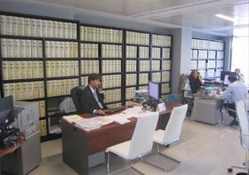 Un grupo de personas están sentadas en escritorios en una oficina.