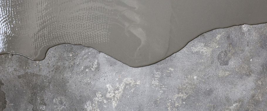 Gros plan d’un bord de tissu gris sur une surface en béton rugueuse