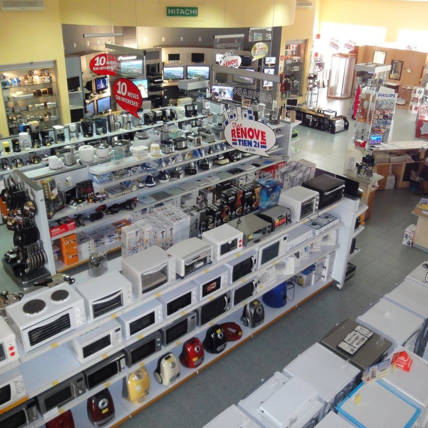 Dentro de una tienda de electrodomésticos, filas de microondas, tostadoras y otros aparatos electrónicos de cocina exhibidos en los estantes.