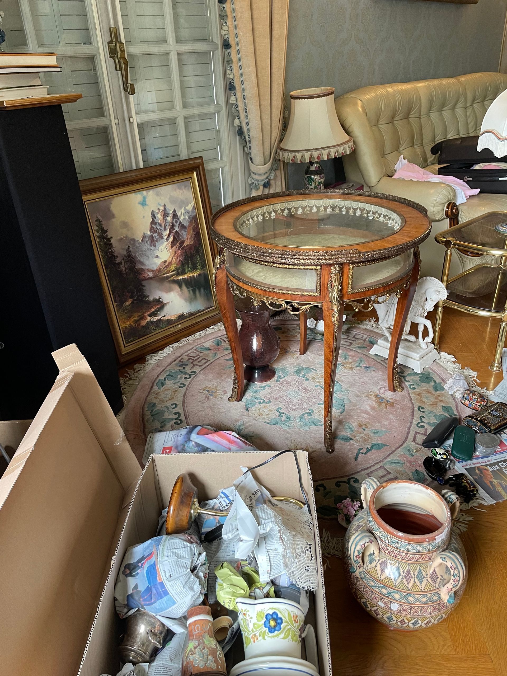 Une belle table basse sertie d'éléments brillants au milieu d'autres meubles et objets à débarrasser
