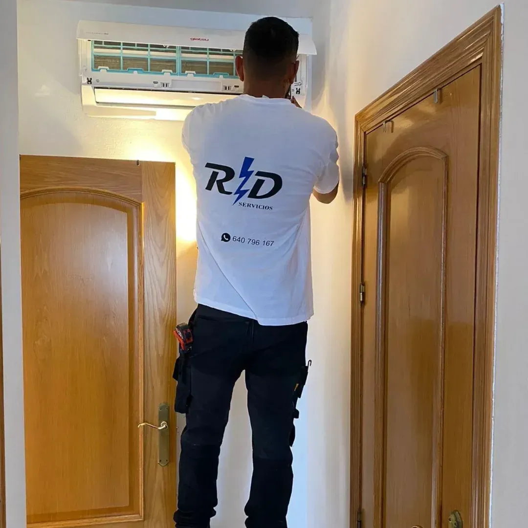 Persona colgando una camisa blanca en el marco de una puerta dentro de una habitación con puertas de madera.