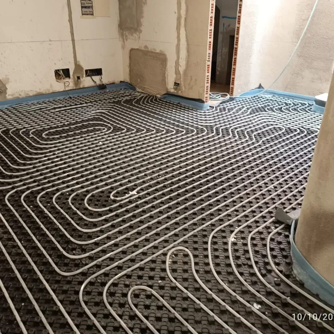 Tuberías de calefacción por suelo radiante colocadas sobre el aislamiento en una habitación