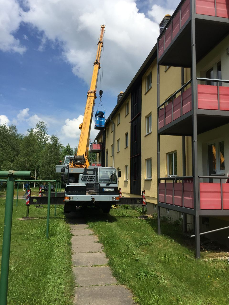 Kran der Firma C.G.D. Spedition Marlene Löwe bei einem Mehrfamilienhaus