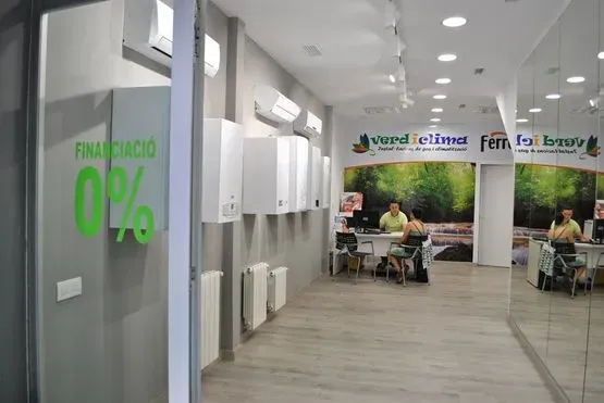 Un hombre está sentado en un escritorio en una habitación con un cartel que dice 0%.