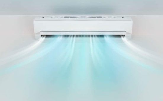 Un acondicionador de aire blanco sopla aire frío en una habitación.