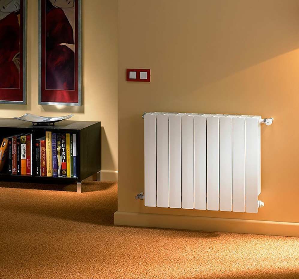 Una sala de estar con una estantería y un radiador blanco.