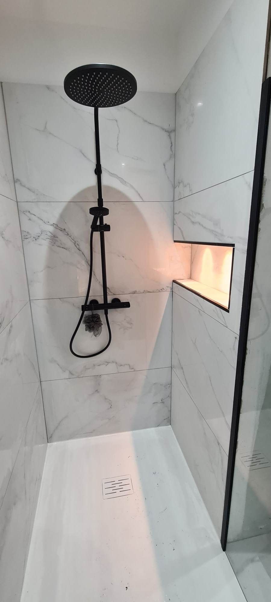 Une douche avec carrelage à effet marbre