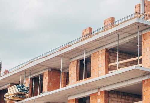 Se está construyendo un edificio con ladrillos y andamios.