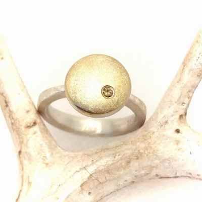 Ring mit großem kreisförmigen Element und Diamant