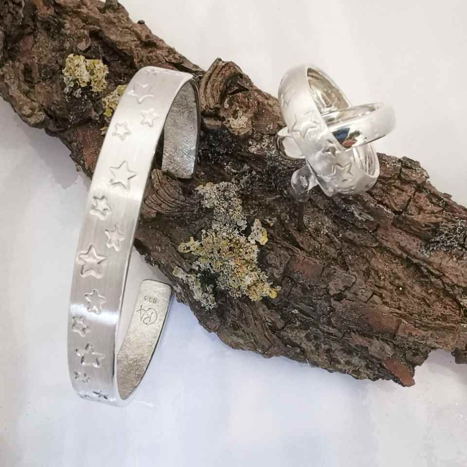 Ring und Armreif mit Sternenmotiv auf Holzstück