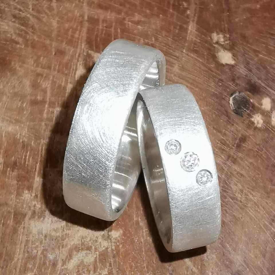 zwei Eheringe, einer mit drei Diamanten
