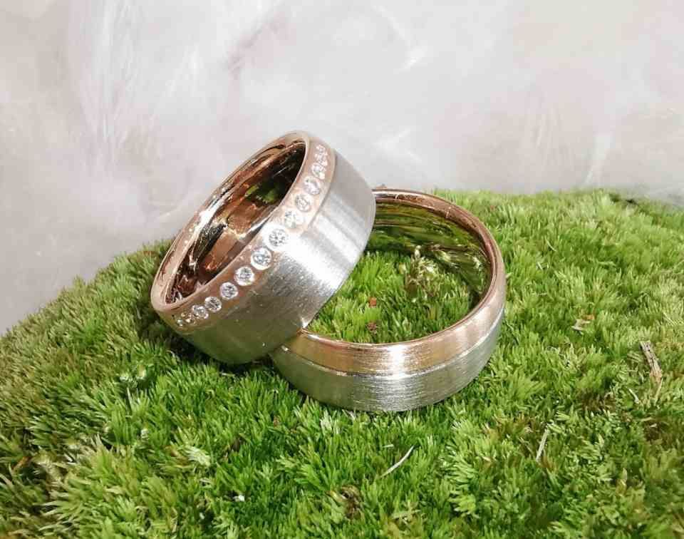 zwei zweifarbige Eheringe, einer davon mit Diamantenband