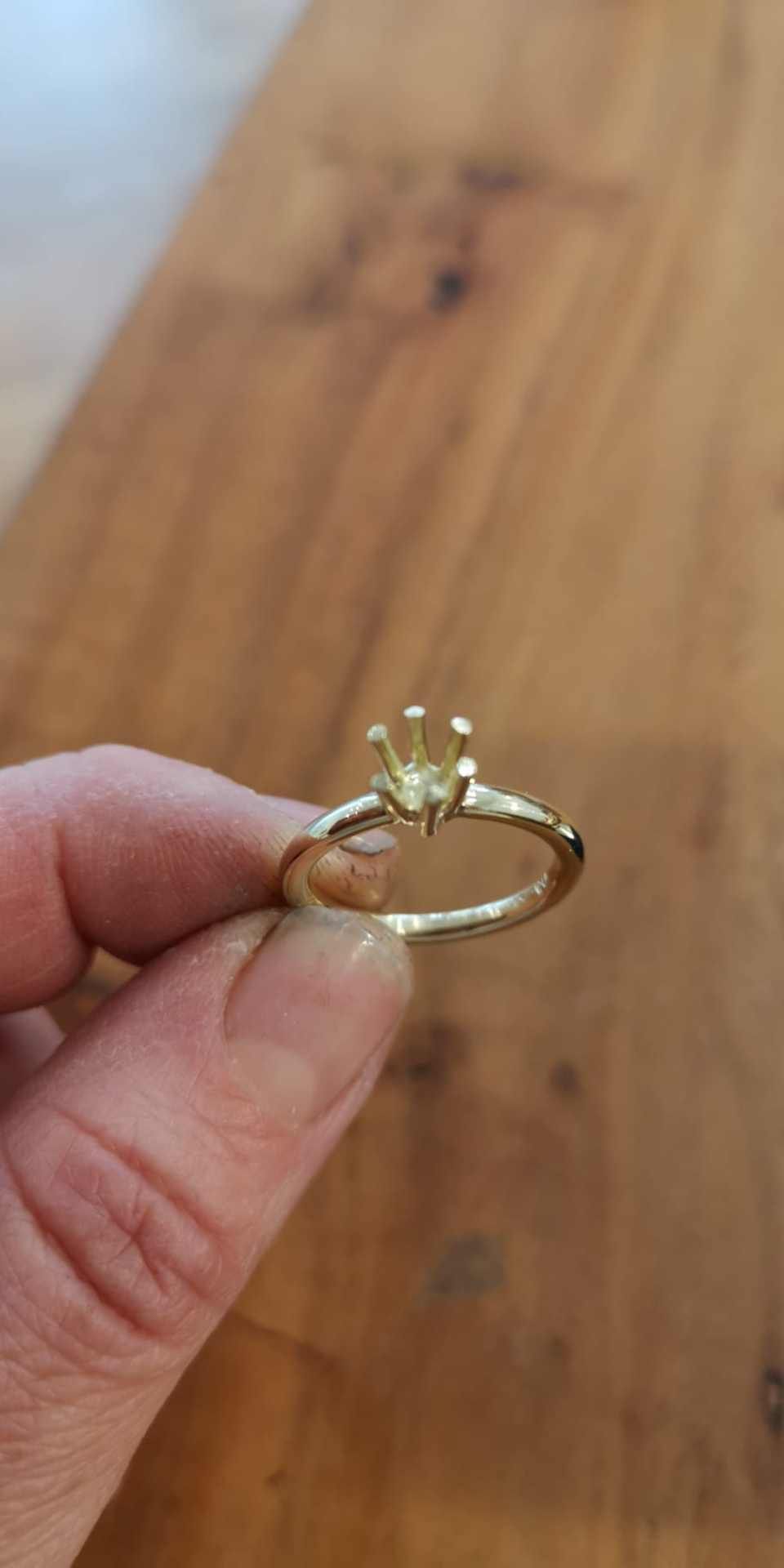 zwei Finger halten einen Ring mit Krone